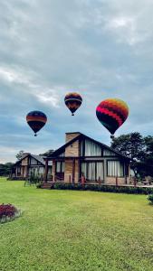 three hot air balloons flying over a house at Mirador da Montanha in Praia Grande