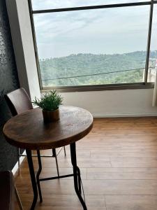 a table and a chair in a room with a large window at Panoramic View in ‘Isfiyā