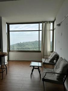 uma sala de estar com uma grande janela e um sofá em Panoramic View em ‘Isfiyā
