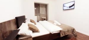 a bedroom with a bed with white sheets and pillows at CLASSY 2-Dormitoare in Baia Mare