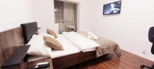 a bedroom with a bed with white sheets and pillows at CLASSY 2-Dormitoare in Baia Mare