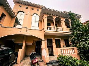 a house with a motorcycle parked in front of it at Love Lounge - Luxury 3BHK Villa in Greater Noida in Noida