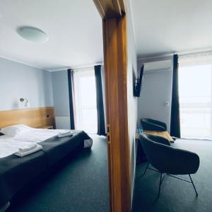 a hotel room with a bed and a chair at Hotel Galion in Gdańsk