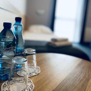 two bottles and glasses sitting on a wooden table at Hotel Galion in Gdańsk