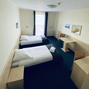 a hotel room with two beds and a desk at Hotel Galion in Gdańsk