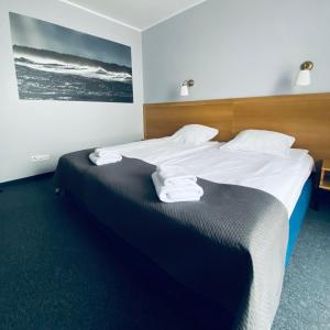 a bedroom with a large bed with towels on it at Hotel Galion in Gdańsk