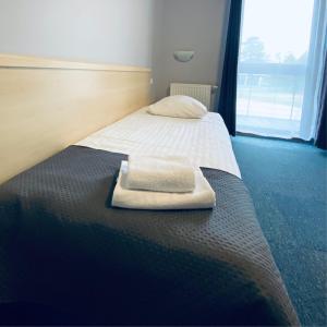 a bed with a towel sitting on top of it at Hotel Galion in Gdańsk