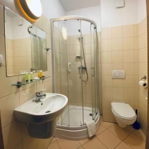 a bathroom with a shower and a sink and a toilet at Hotel Galion in Gdańsk