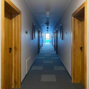 a hallway of an office building with wooden doors at Hotel Galion in Gdańsk