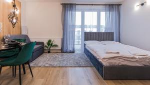 um quarto com uma cama, uma mesa e uma cadeira em VacationClub - Apartamenty Zakopiańskie Apartament 412 em Zakopane mais 14 fotografias