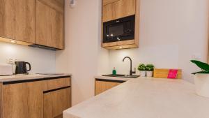 uma cozinha com pia e micro-ondas em VacationClub - Apartamenty Zakopiańskie Apartament 412 em Zakopane