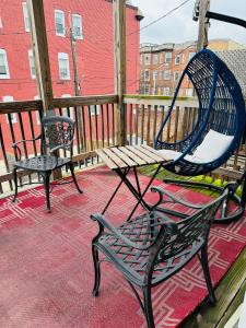 two benches sitting on a porch with a large mirror at Entire Modern Home near Stadiums, Hospitals, and Schools in Baltimore