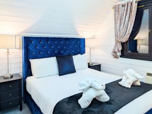 two stuffed animals sitting on a bed in a bedroom at Danu 1A -Hot Tub-Perth-Pet Friendly-Luxury-Romantic in Perth