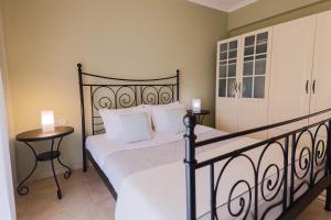 a bedroom with two beds with white sheets and white pillows at Mareva's house in Vromerí