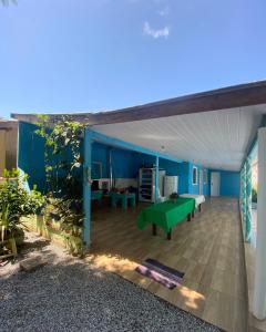 sala de estar con mesa verde y pared azul en Calli Pontal do Sul en Pontal do Paraná