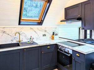 a kitchen with blue cabinets and a sink and a window at Danu 1A -Hot Tub-Perth-Pet Friendly-Luxury-Romantic in Perth