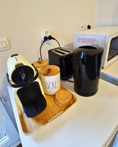 uma bancada com comodidades para preparar café e um micro-ondas em [Cosy] Appartement équipé avec terrasse, Wifi em Pont-de-la-Maye