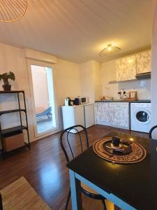 uma cozinha e sala de jantar com mesa e cadeiras em [Cosy] Appartement équipé avec terrasse, Wifi em Pont-de-la-Maye