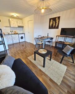 uma sala de estar com um sofá e uma mesa em [Cosy] Appartement équipé avec terrasse, Wifi em Pont-de-la-Maye