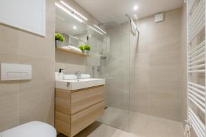 a bathroom with a sink and a shower at Admiral Luxury Stúdió Apartman By BLTN in Siófok
