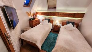 2 łóżka w małym pokoju z: w obiekcie Rezydencja Tatry - Apartament Chamerion 1 w Zakopanem