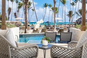 a pool at the resort with chairs and a table at Secrets Tides Punta Cana - All Inclusive in Punta Cana