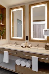 a bathroom with two sinks and two mirrors at Secrets Tides Punta Cana in Punta Cana