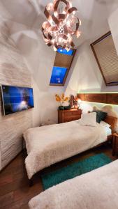 sypialnia z 2 łóżkami i żyrandolem w obiekcie Rezydencja Tatry - Apartament Chamerion 1 w Zakopanem