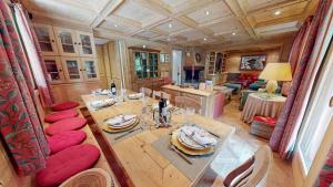 Un comedor con una mesa y sillas rojas. en Chalet La Grande Ourse Meribel - 165m2 apartment almost ski-in ski-out, en Méribel