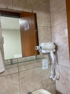 a bathroom with a mirror and a white hair dryer at Pousada Flor De Brasília in Brasilia