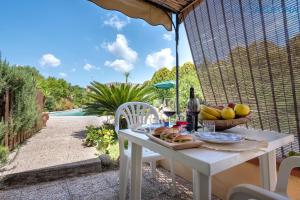 a table with a basket of fruit and a bottle of wine at Cottage Soraya with independent swimming pool near the beach in Sassari