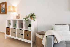a living room with a white book shelf and a couch at Casita Caracol - peace and quiet in Denia