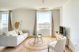 a living room with a couch and a table at Appartement Bécasseau - La Maison Heureuse - Welkeys in Saint-Georges-dʼOléron