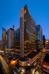 een hoog gebouw met een klokkentoren in een stad bij Sheraton New York Times Square Hotel in New York