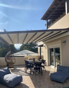 a patio with a table and chairs and an umbrella at Villa KIMA Heated Pool in Episkopi (Heraklion)