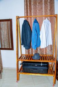 a clothes rack with clothes hanging in a room at Happiness at the center of the town morogoro in Morogoro