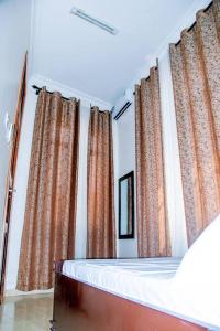 a bedroom with orange curtains and a bed at Happiness at the center of the town morogoro in Morogoro
