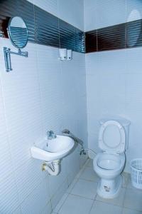 a small bathroom with a toilet and a sink at Happiness at the center of the town morogoro in Morogoro