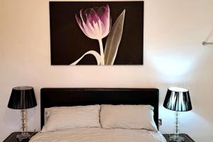 una pintura de una flor rosa sobre una cama en Hideaway Apartment nr. Zipworld, en Aberdare