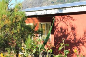 a red house with plants in front of it at la colorida 2 in Lago Puelo