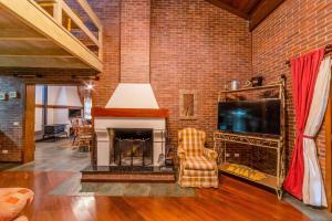 ein Wohnzimmer mit Kamin und Fernseher in der Unterkunft Bela casa estilo chalé em Canela RCF160 in Canela