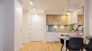 a kitchen and dining room with a table and chairs at VacationClub - Apartamenty Zakopiańskie Apartament 137 in Zakopane