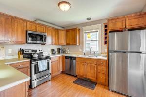 a kitchen with wooden cabinets and stainless steel appliances at Charming Kalamazoo Home with Yard 1 Mi to Downtown! in Kalamazoo
