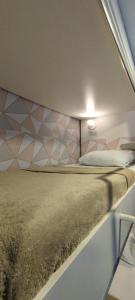 a bedroom with a large bed with a wall at GVR Praia Hostel in João Pessoa