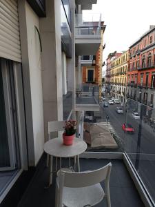 a table and chairs on a balcony with a view of a city at Tema Suites in Naples