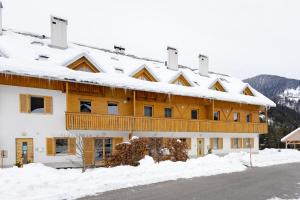 un grand bâtiment avec de la neige sur le toit dans l'établissement Waterfall Apartment - Cozy Mountain Retreat, à Kranjska Gora