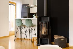 une cuisine avec deux chaises vertes et un comptoir dans l'établissement Waterfall Apartment - Cozy Mountain Retreat, à Kranjska Gora