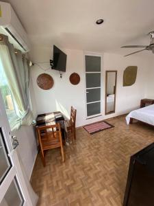 uma sala de estar com uma secretária, uma cama e uma televisão em Casa ka'an em Isla Mujeres
