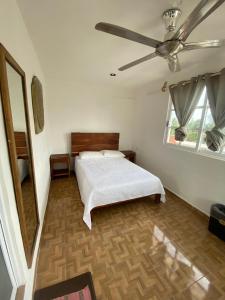 um quarto com uma cama e uma ventoinha de tecto em Casa ka'an em Isla Mujeres