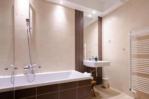 une salle de bain avec une baignoire et un lavabo dans l'établissement Waterfall Apartment - Cozy Mountain Retreat, à Kranjska Gora 42 autres photos